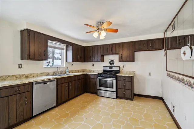 a kitchen with stainless steel appliances granite countertop a stove sink and refrigerator