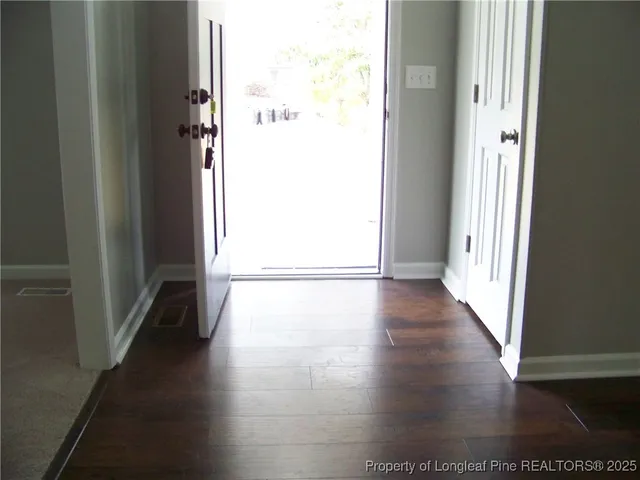 a view of a hallway with wooden floor