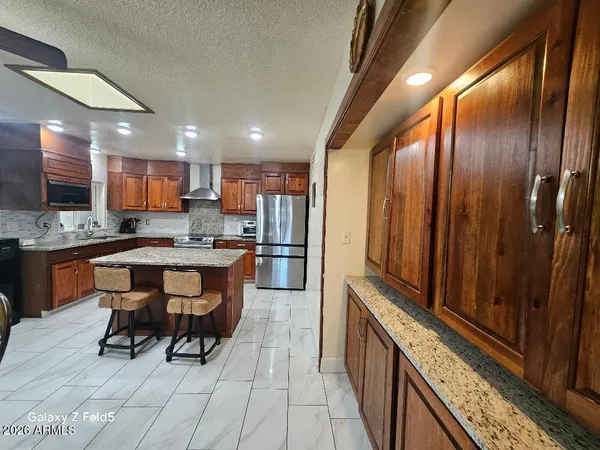 a kitchen with stainless steel appliances granite countertop wooden cabinets a sink and a stove