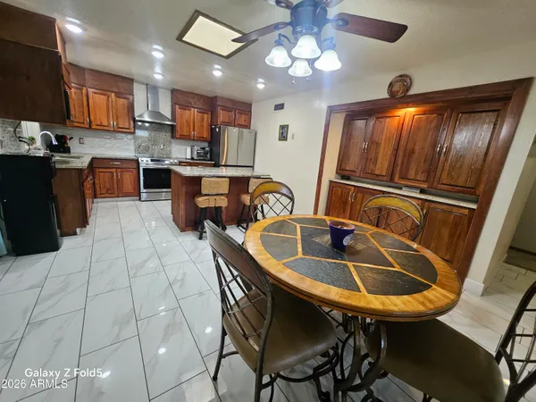 a kitchen with kitchen island granite countertop a sink a counter space appliances and cabinets