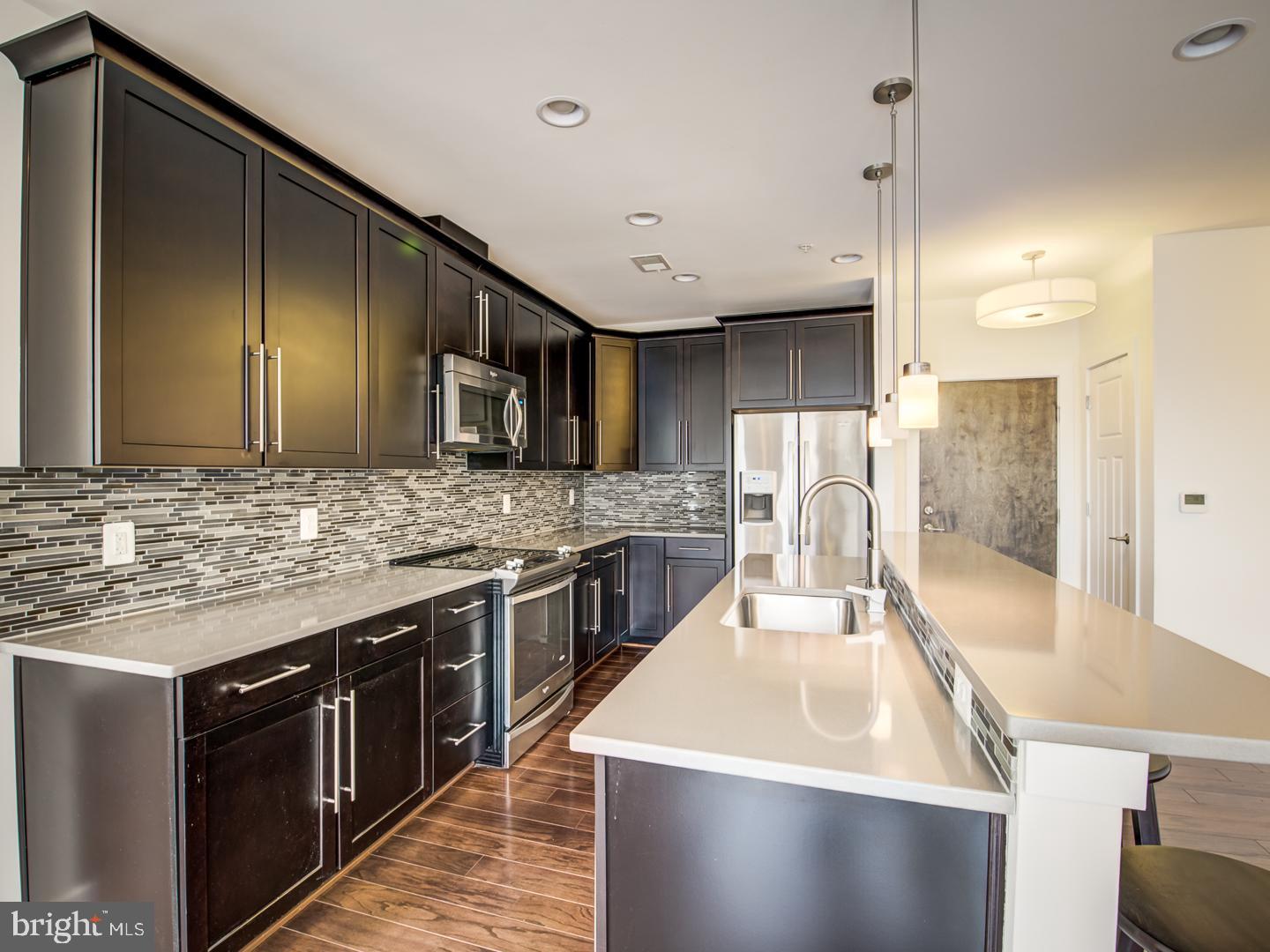 1107 South Walter Reed Drive, Unit 302 Arlington, VA 22204 - Photo 18 of 50 a large kitchen with stainless steel appliances wooden cabinets and a counter top space