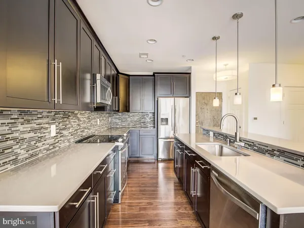 a kitchen with stainless steel appliances a sink stove and cabinets