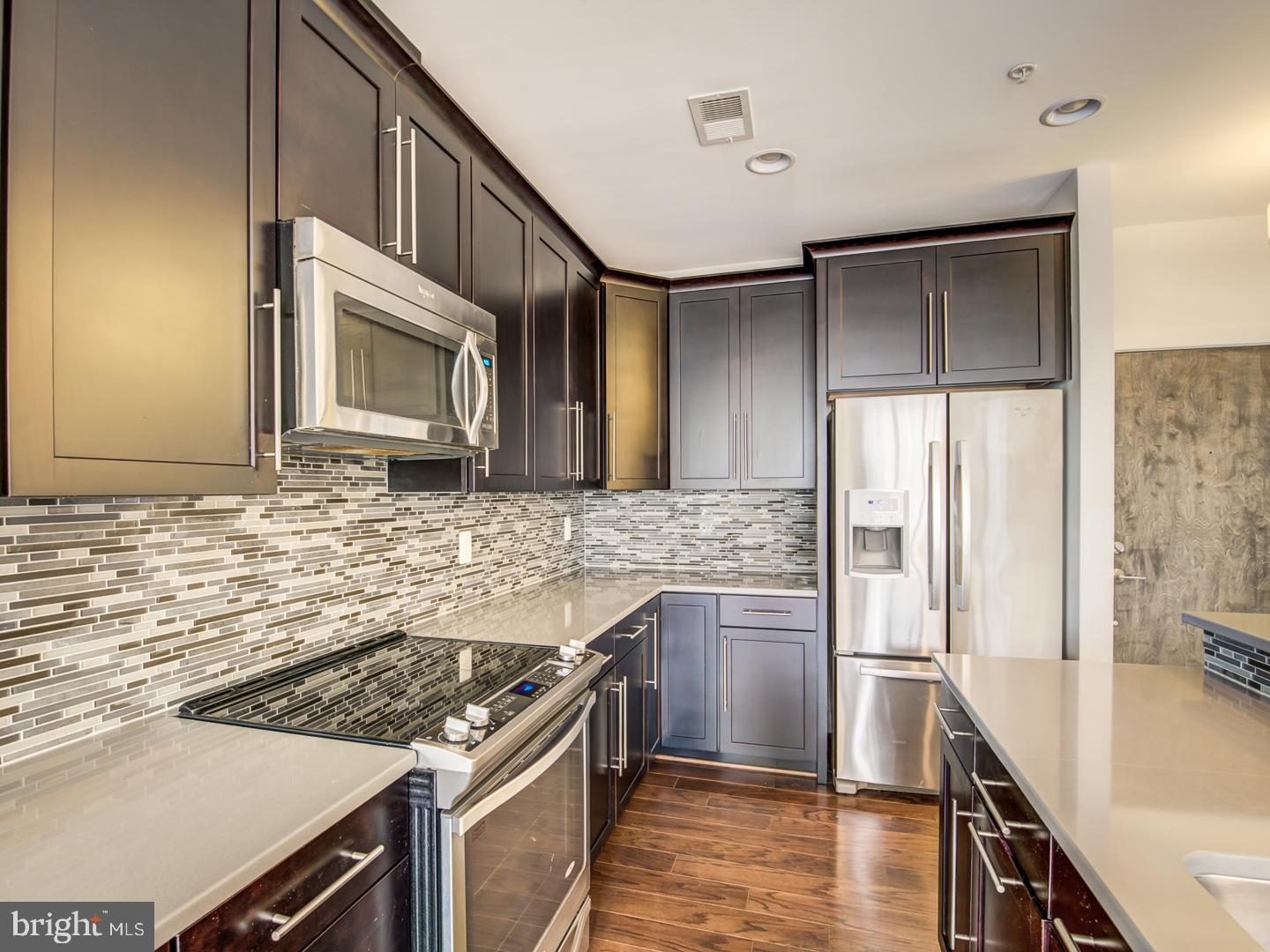 1107 South Walter Reed Drive, Unit 302 Arlington, VA 22204 - Photo 21 of 50 a kitchen with stainless steel appliances granite countertop a stove refrigerator and microwave