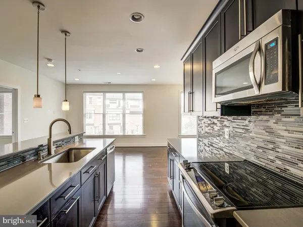 a kitchen with stainless steel appliances stove a sink and a microwave