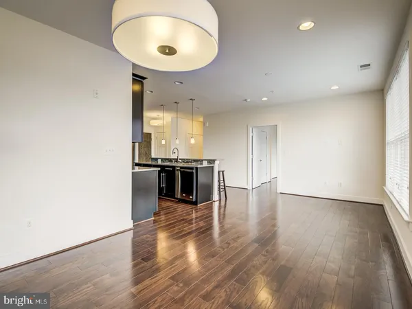 an empty room with wooden floor and entrance