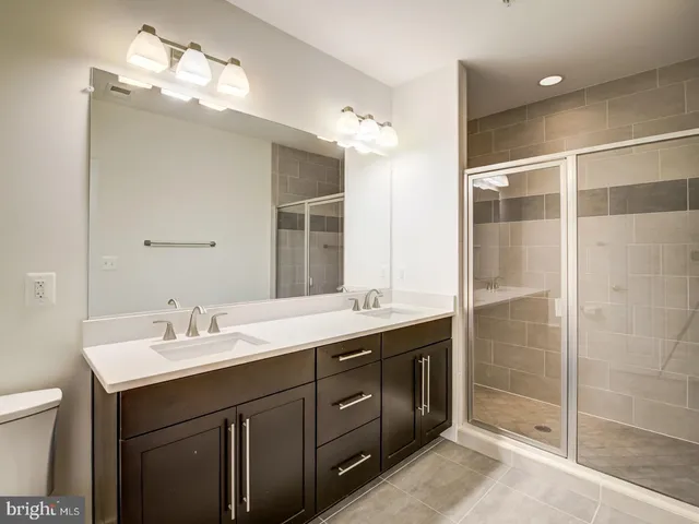 a bathroom with a double vanity sink mirror and shower