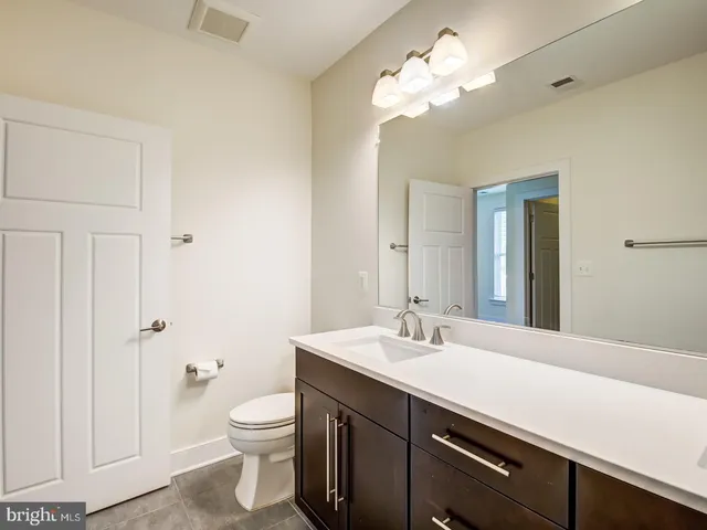 a bathroom with a double vanity sink toilet and a mirror