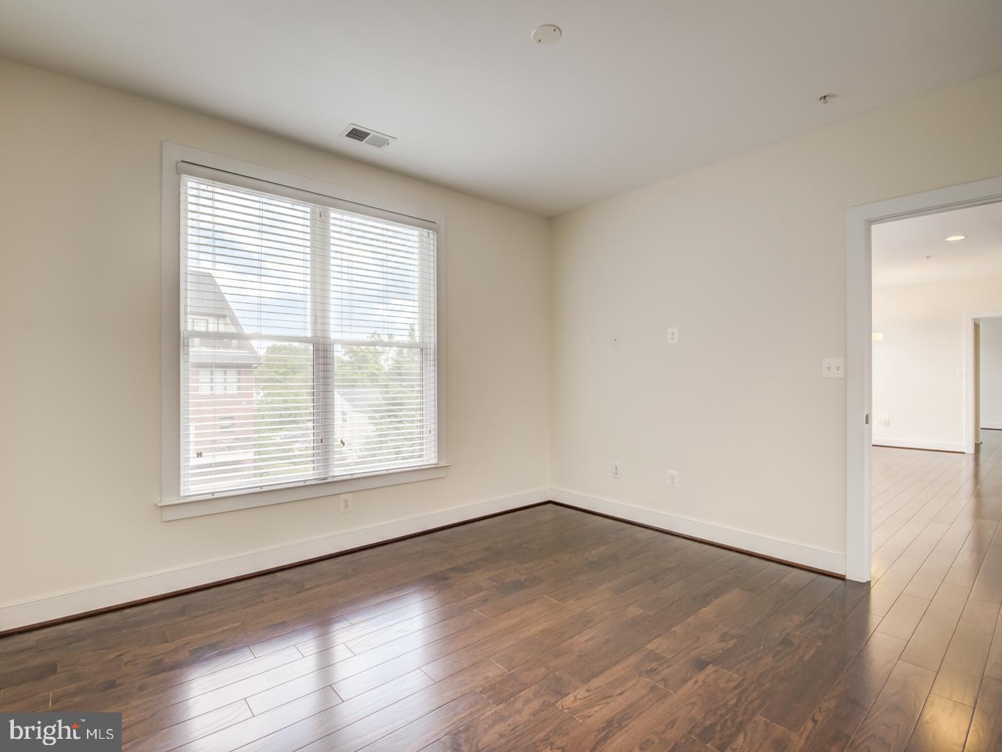 1107 South Walter Reed Drive, Unit 302 Arlington, VA 22204 - Photo 38 of 50 an empty room with wooden floor and windows