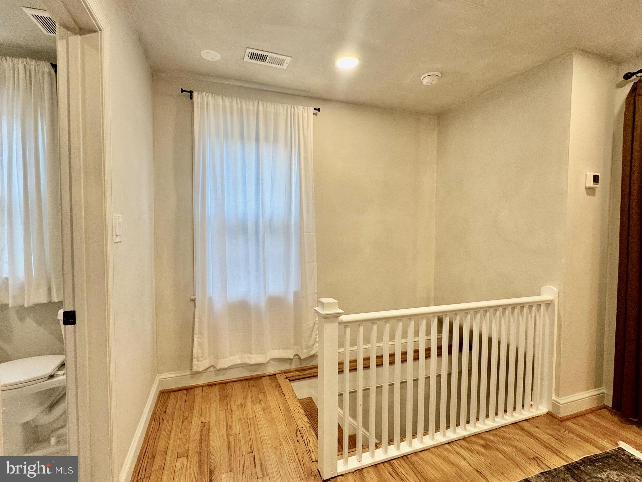 6017 Inwood Street Landover, MD 20785 - Photo 21 of 33 a view of a hallway with wooden floor and a bathroom