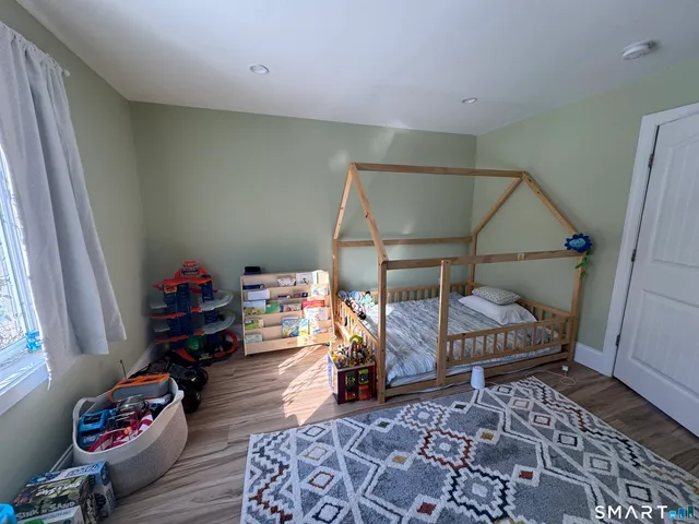 a bedroom with a bed and wooden floor