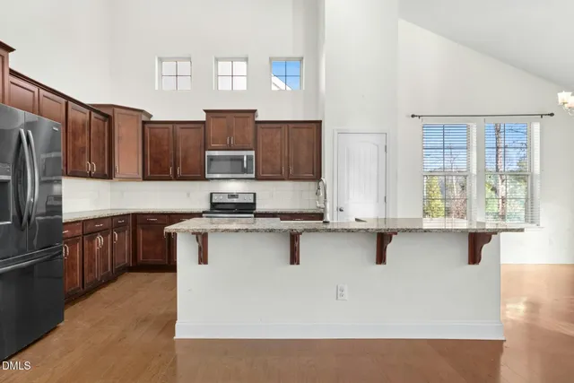 a view of kitchen with kitchen island and stainless steel appliances