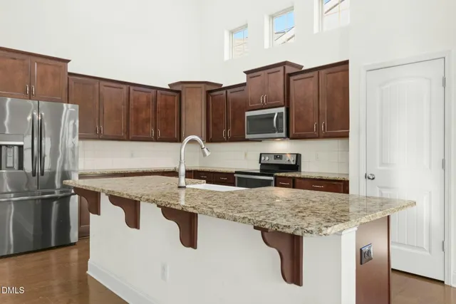 a kitchen with stainless steel appliances granite countertop a sink stove and refrigerator