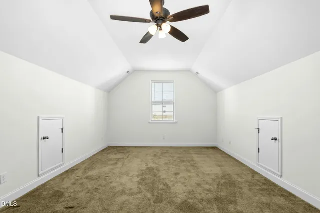 an empty room with chandelier fan