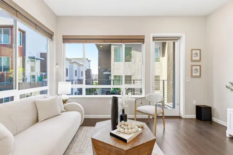 a living room with furniture kitchen view and a large window