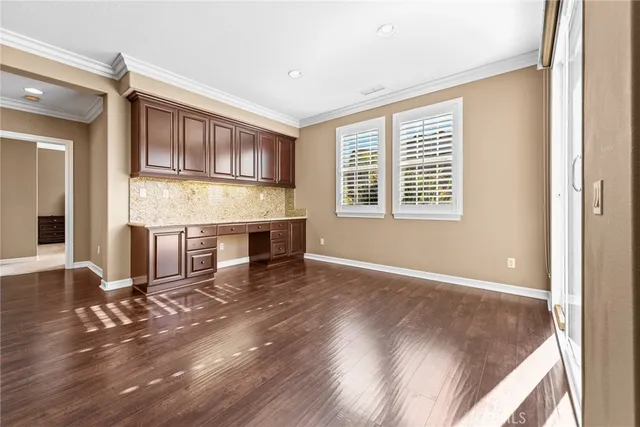 a kitchen with stainless steel appliances kitchen island granite countertop wooden cabinets and a refrigerator