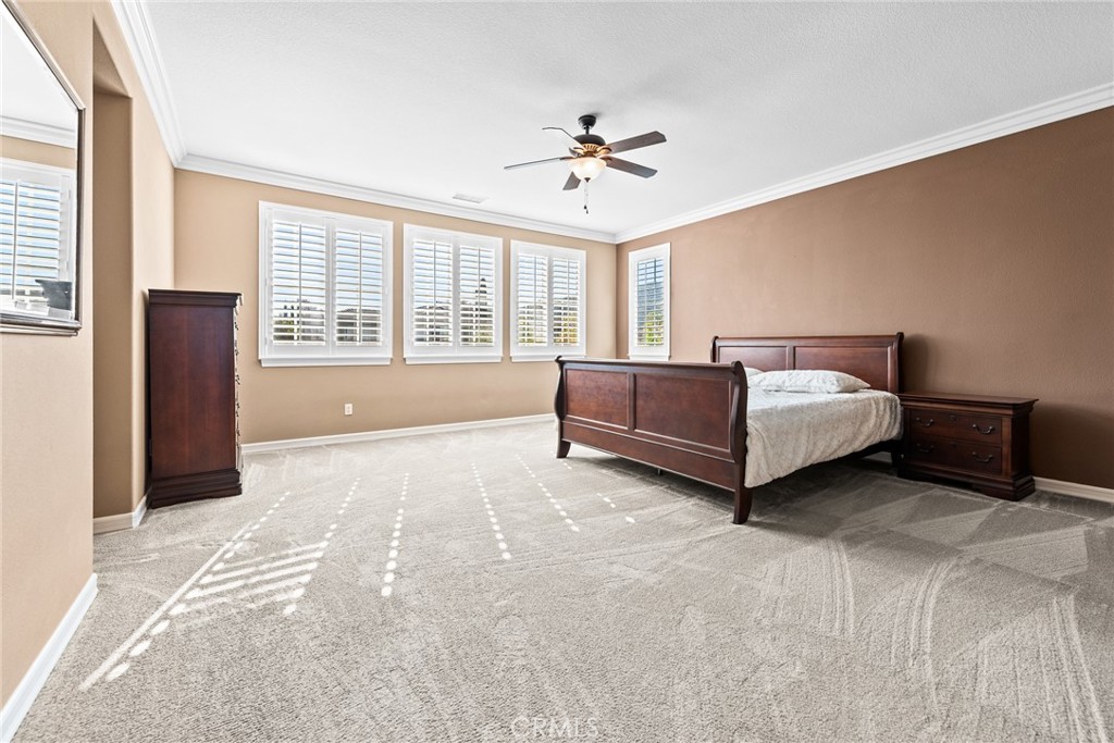 32437 Yosemite Lane Temecula, CA 92592 - Photo 33 of 63 a spacious bedroom with a bed and a chandelier