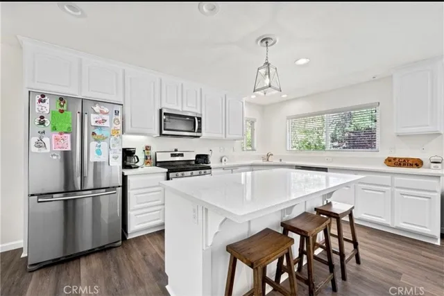 a kitchen with granite countertop a center island stainless steel appliances cabinets and a window
