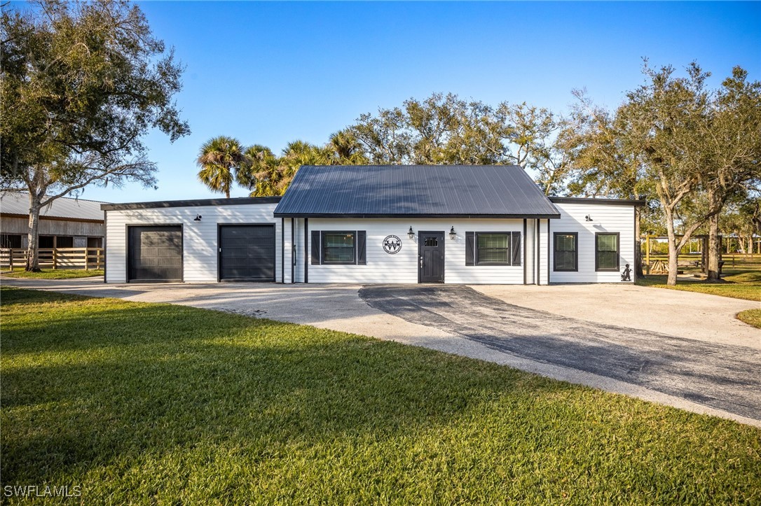 12251 Old Rodeo Drive Alva, FL 33920 - Photo 23 of 49 a front view of a house with a garden