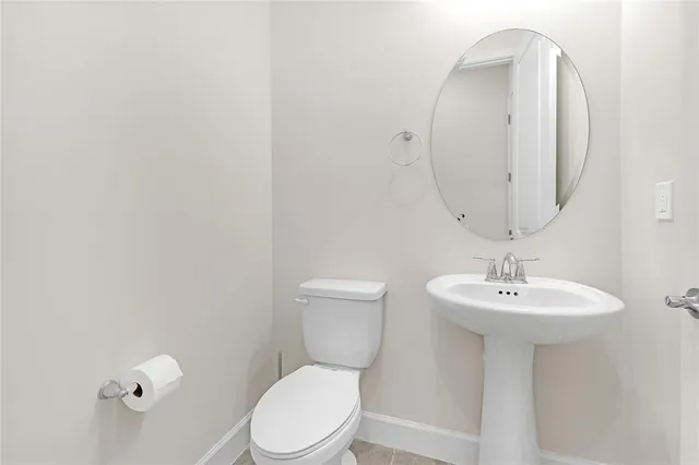 a bathroom with a toilet a sink and mirror