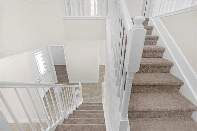 a view of staircase with white walls and a window