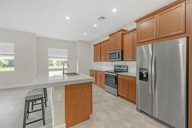 a kitchen with granite countertop a refrigerator stove top oven and sink