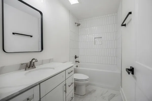 a bathroom with a granite countertop sink a toilet and shower