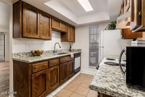 a kitchen with granite countertop a sink stove and refrigerator