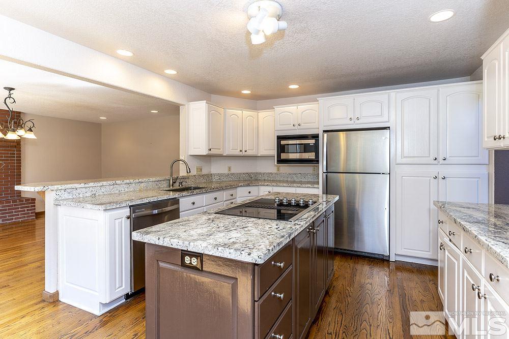 725 Arius Court Reno, NV 89512 - Photo 11 of 27 a kitchen with a stove a refrigerator and a sink