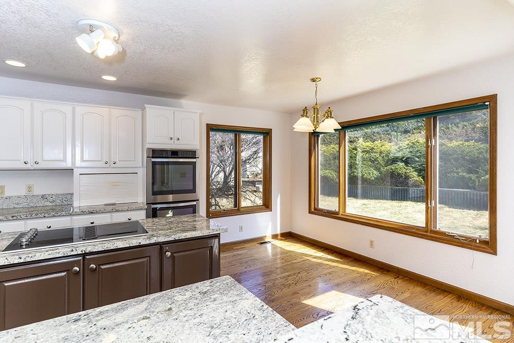 725 Arius Court Reno, NV 89512 - Photo 12 of 27 a large kitchen with kitchen island a large window cabinets a sink and stainless steel appliances