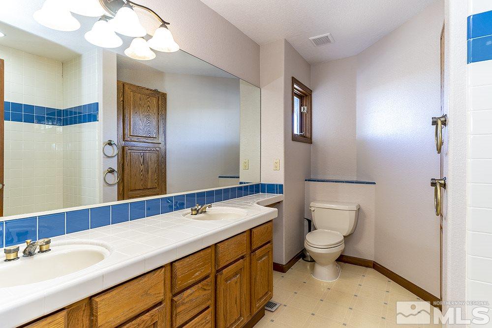 725 Arius Court Reno, NV 89512 - Photo 20 of 27 a bathroom with a sink a toilet and mirror