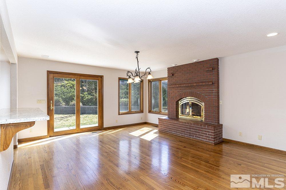 725 Arius Court Reno, NV 89512 - Photo 8 of 27 a view of a livingroom with a fireplace wooden floor and windows