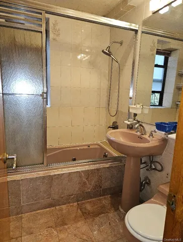 a bathroom with a sink and mirror with toilet