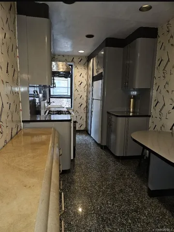 a kitchen with refrigerator and sink