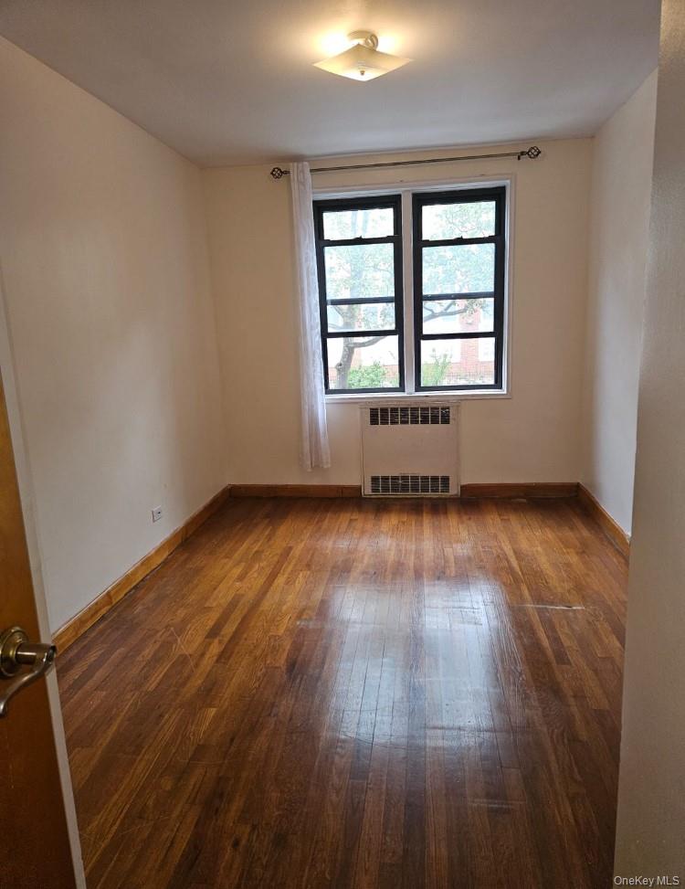 102-18 64th Avenue, Unit 2X Queens, NY 11375 - Photo 6 of 17 an empty room with wooden floor and windows
