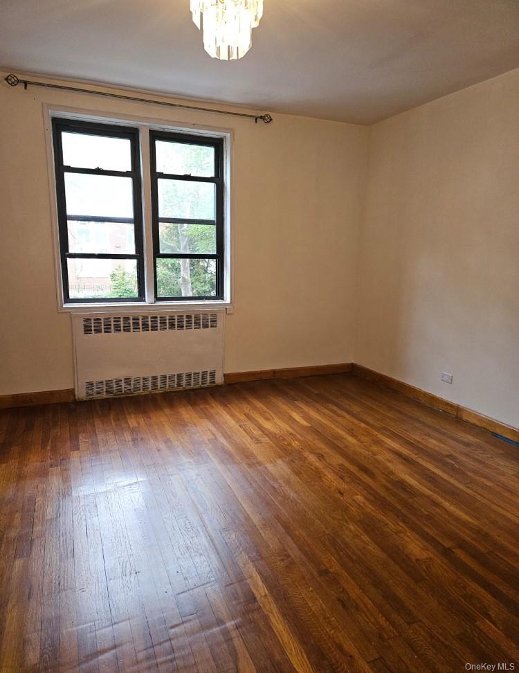 102-18 64th Avenue, Unit 2X Queens, NY 11375 - Photo 8 of 17 an empty room with wooden floor and windows