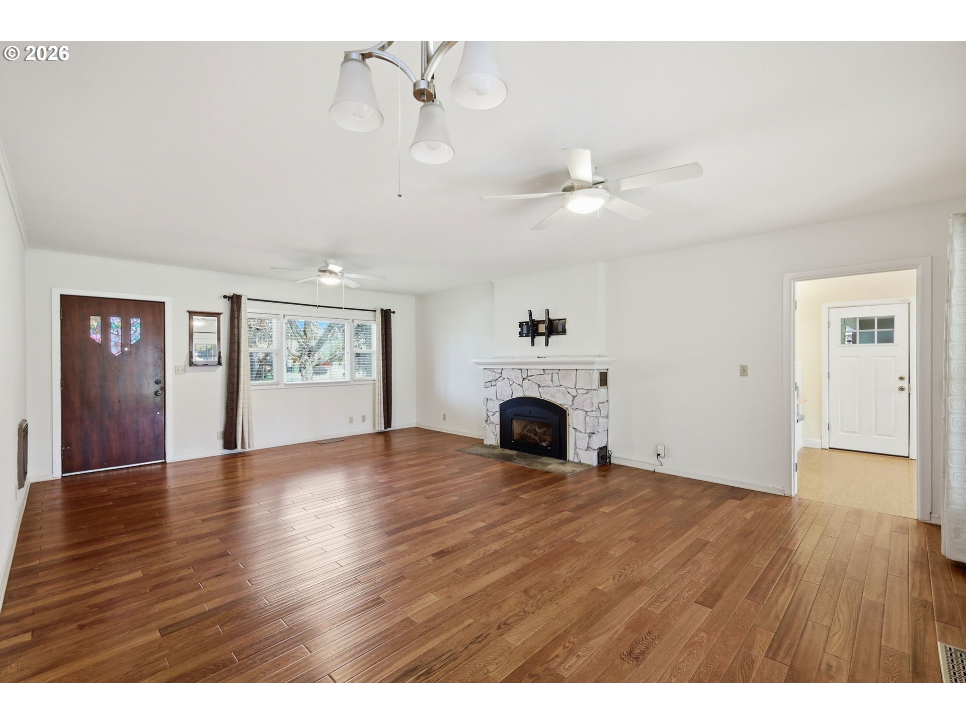 710 South 1st Street Cottage Grove, OR 97424 - Photo 4 of 46 a view of an empty room with a fireplace and wooden floor
