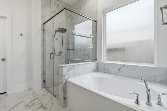 a bedroom with a flat screen tv on dresser and a chandelier