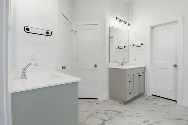 a bathroom with a double vanity sink mirror and shower