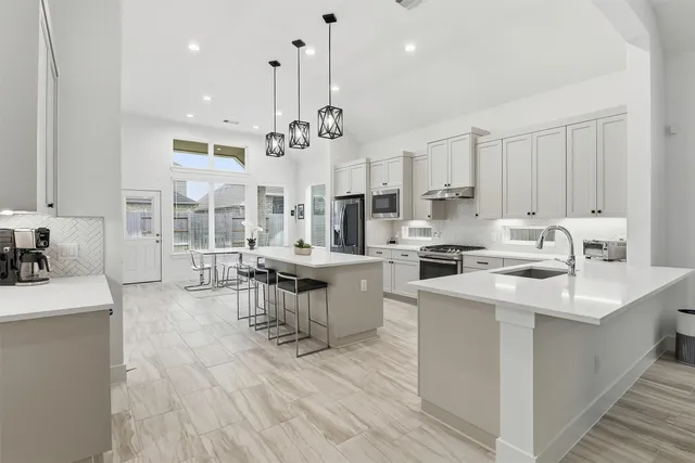 a open kitchen with stainless steel appliances kitchen island a white cabinets and wooden floor