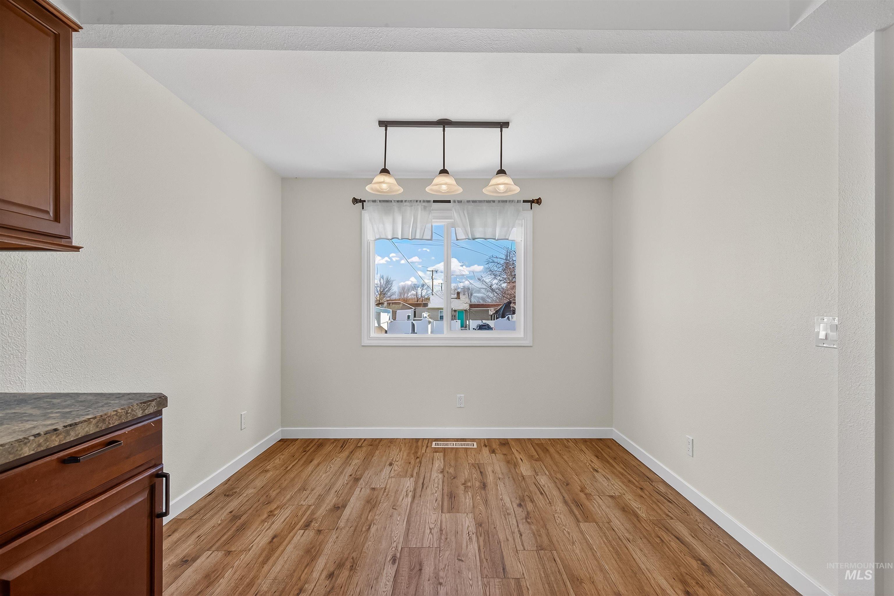1519 17th Street Lewiston, ID 83501 - Photo 14 of 39 Unfurnished dining area featuring light wood-style flooring and baseboards
