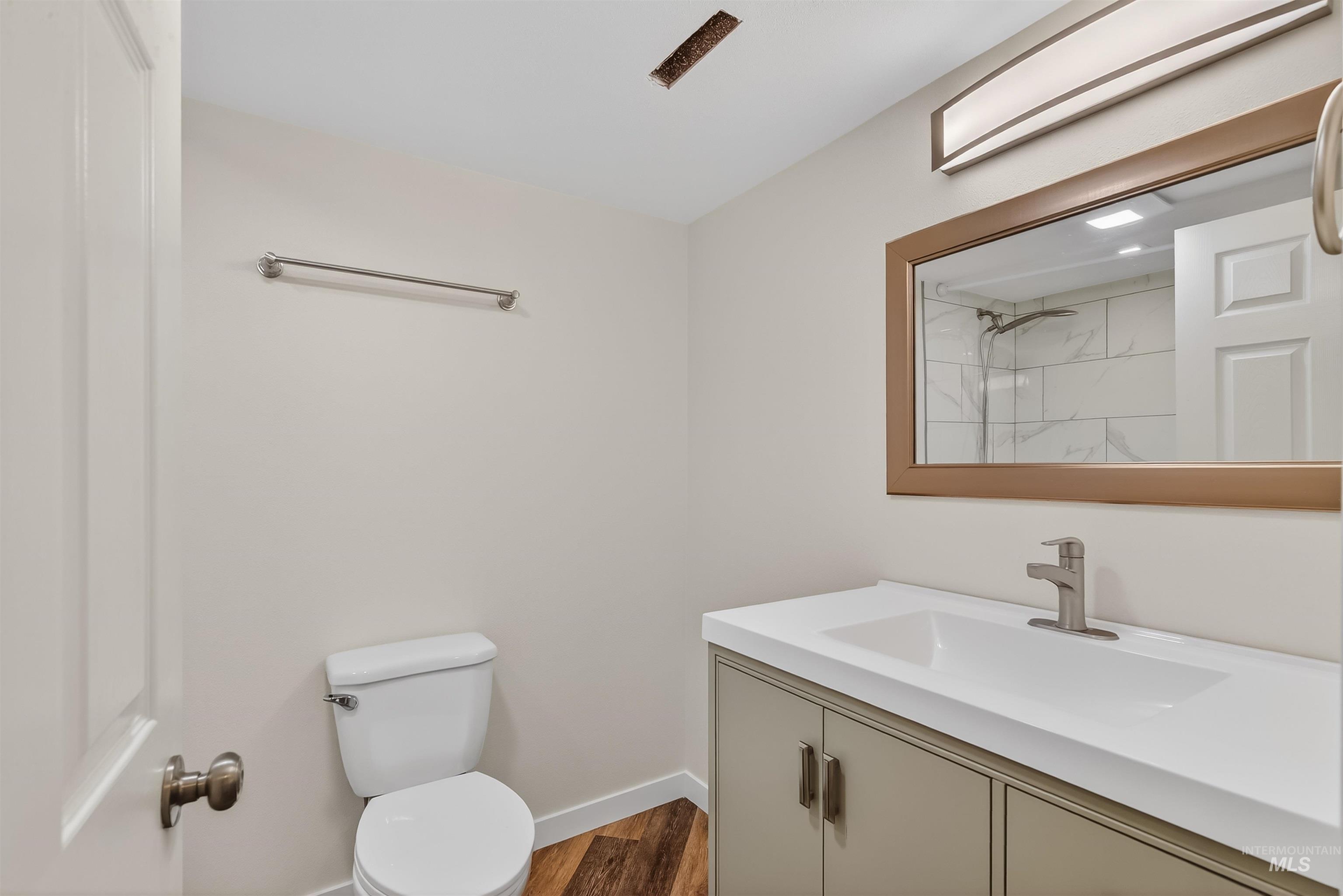 1519 17th Street Lewiston, ID 83501 - Photo 29 of 39 Bathroom featuring vanity, a marble finish shower, and dark wood-style flooring