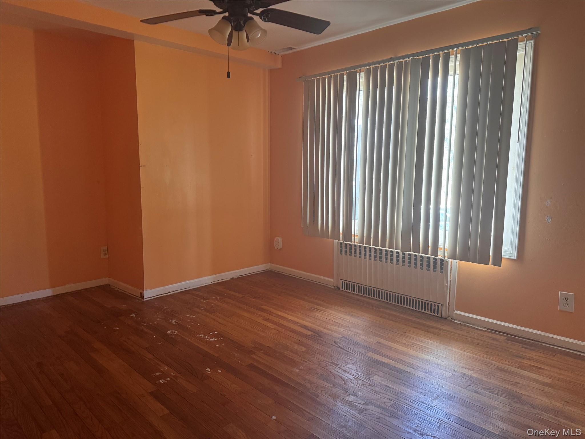 116 Williams Avenue, Unit 101 Spring Valley, NY 10977 - Photo 16 of 23 an empty room with wooden floor and windows