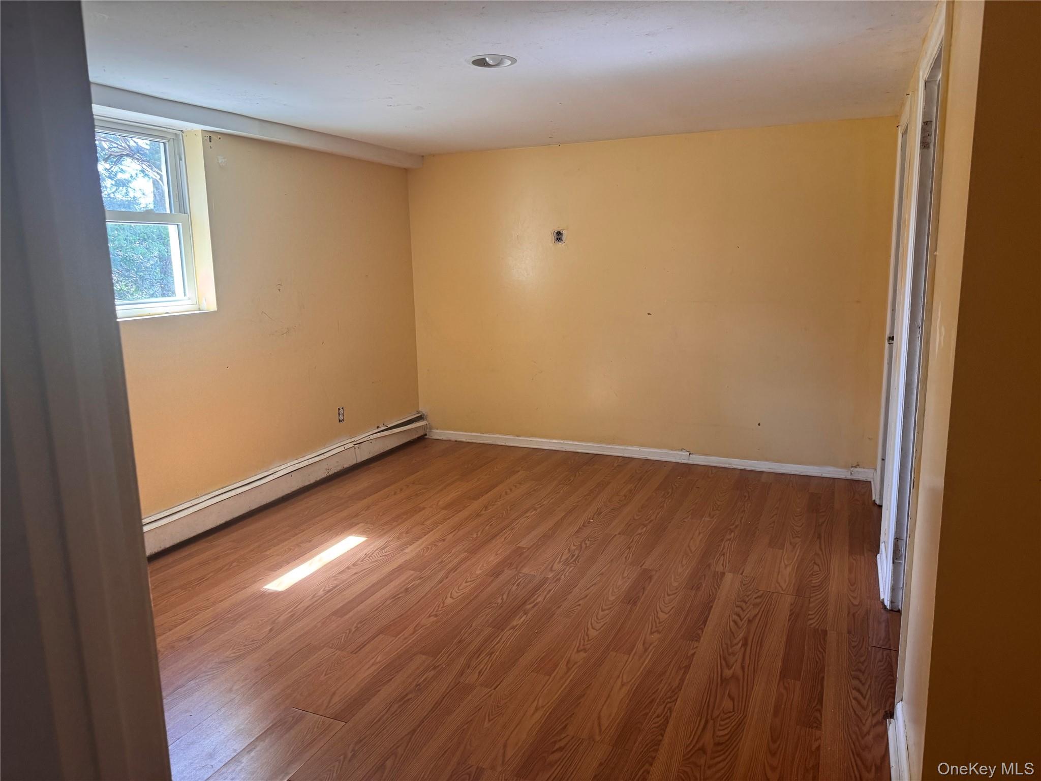 116 Williams Avenue, Unit 101 Spring Valley, NY 10977 - Photo 22 of 23 an empty room with wooden floor and windows