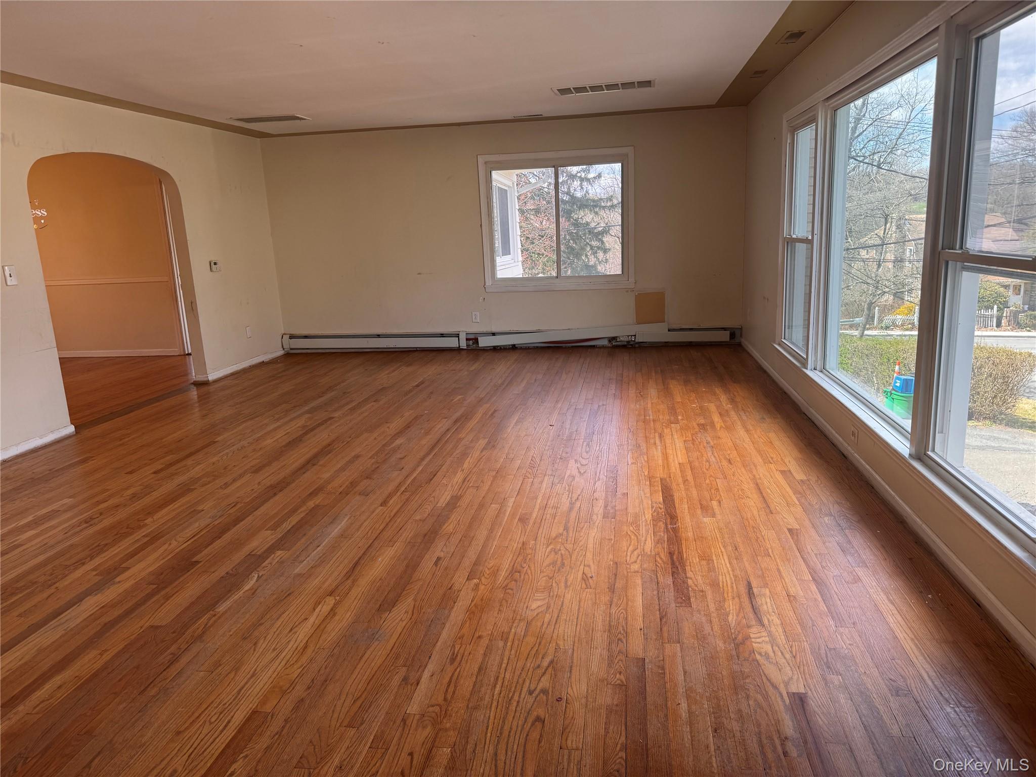 116 Williams Avenue, Unit 101 Spring Valley, NY 10977 - Photo 3 of 23 an empty room with wooden floor and windows