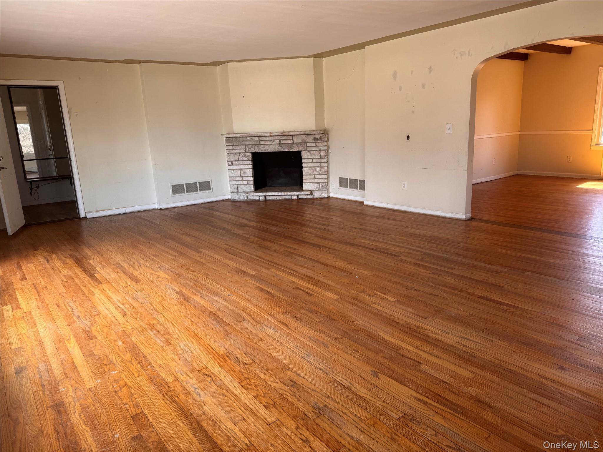 116 Williams Avenue, Unit 101 Spring Valley, NY 10977 - Photo 4 of 23 an empty room with wooden floor and fireplace
