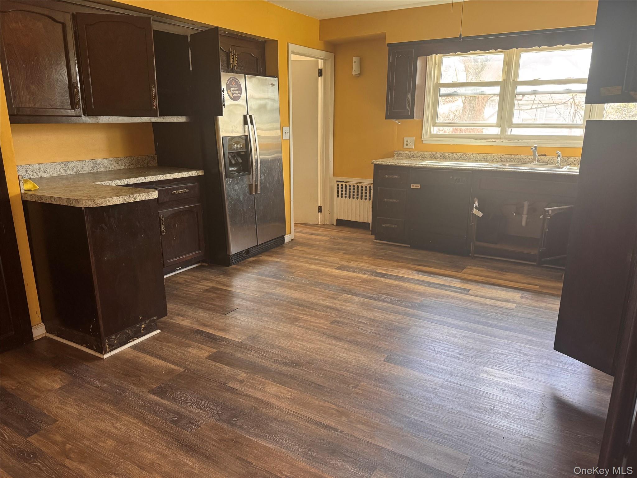 116 Williams Avenue, Unit 101 Spring Valley, NY 10977 - Photo 8 of 23 a kitchen with granite countertop a refrigerator and wooden cabinets