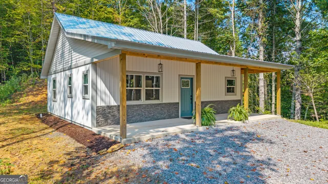 a view of house with backyard and glass windows