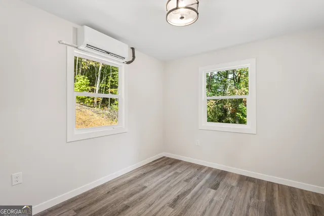 an empty room with a window and wooden floor
