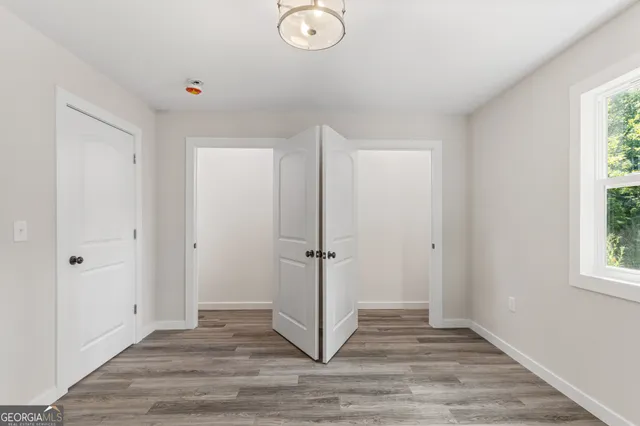 a view of a livingroom with wooden floor and window