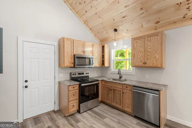 a kitchen with stainless steel appliances a sink stove and cabinets